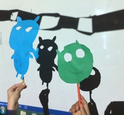 children hands holding home-made shadow puppets