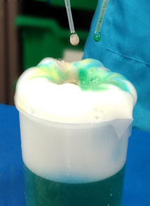 child dripping colours into foaming beaker