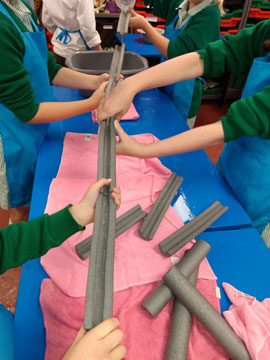 children holding and pouring water down chute